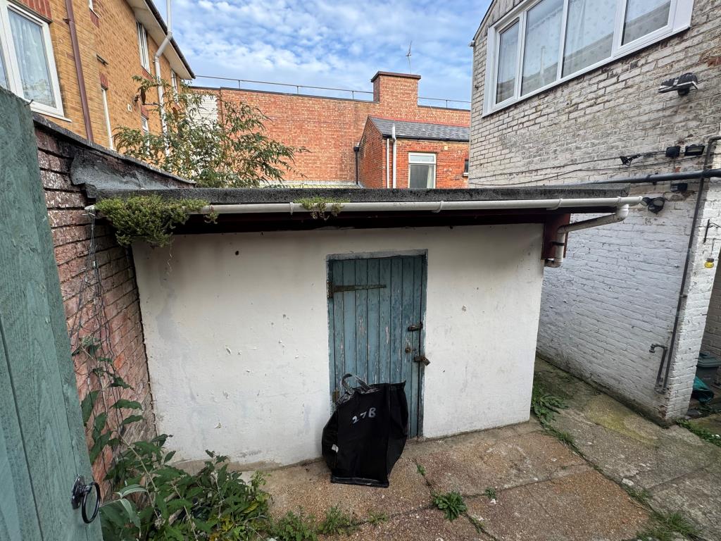 Lot: 94 - DOUBLE-FRONTED HIGH STREET SHOP WITH LARGE REAR STORES WITH POTENTIAL AND FREEHOLD INTEREST IN TWO FLATS OVER - Store Shed at the rear